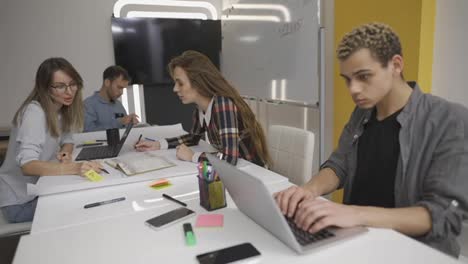 Junge-Kreative-Geschäftsleute-Kommunizieren,-Arbeiten-Mit-Laptops-Im-Büro