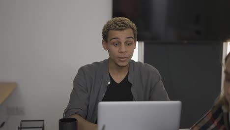 Young-business-coworkers-in-the-office,-mixed-race-man-has-a-video-conference