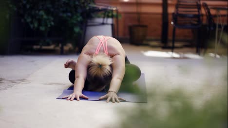 Yogi-woman-performing-bending-asana-outdoors
