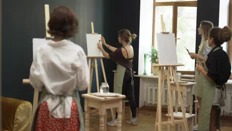 Grupo-De-Estudiantes-Pintando-En-Una-Lección-De-Arte-En-El-Estudio