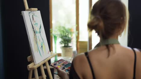 Artista-Femenina-En-Delantal-Pintando-Un-Cuadro-Sobre-Lienzo-En-Un-Estudio-De-Arte