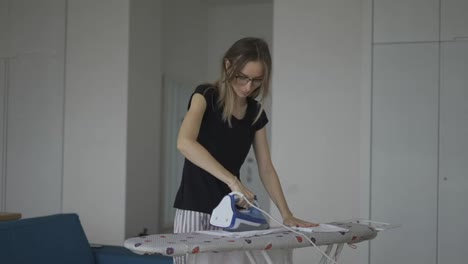 Woman-ironing-clothes-at-home-on-board