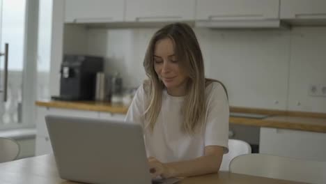 Smiling-woman-reading-good-news-or-surfing-internet-on-laptop