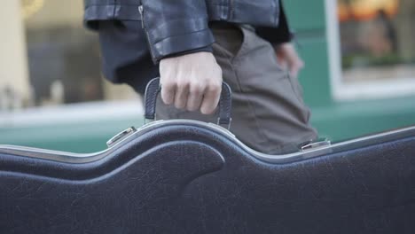 Man-Carrying-Guitar-Case-in-the-city