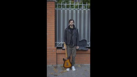 Happy-guy-smiling-on-the-street-with-a-guitar