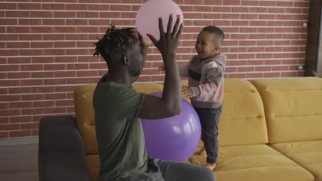 Afroamerikanischer-Vater,-Der-Mit-Einem-Süßen-Kleinen-Jungen-Spielt-Und-Zwei-Luftballons-Benutzt