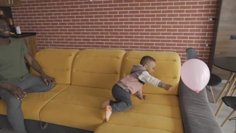 Afroamerikanischer-Vater-Spielt-Mit-Kleinem-Jungen-Im-Wohnzimmer
