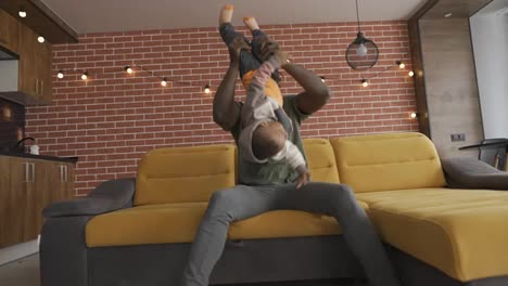 Afrikanischer-Vater-Spielt-Mit-Seinem-Kleinen-Entzückenden-Sohn-Und-Hat-Spaß-Auf-Dem-Sofa