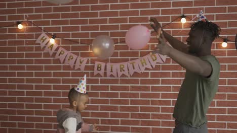 Vater-Und-Sohn-Spielen-Ballon-Auf-Geburtstagsfeier-Zu-Hause