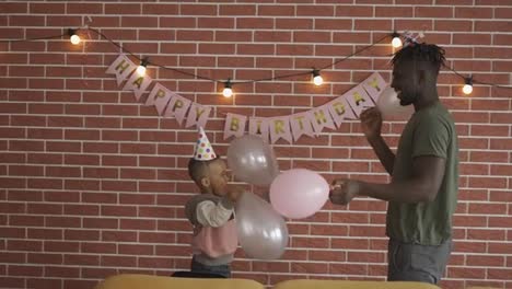 Dad-and-son-playing-ballons-on-birthday-party-at-home
