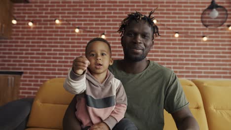 Retrato-Padre-Afroamericano-Y-Niño-En-Edad-Preescolar-Hablan-En-Conversación-Video-Chat-Desde-Casa