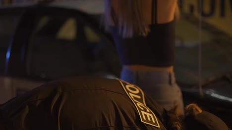 Oficial-De-Policía-Supervisando-A-Una-Mujer-En-La-Ciudad-De-Noche.