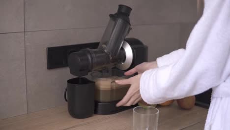 Woman-made-apple-juice-using-juicer,-pouring-fresh-juice-into-glass
