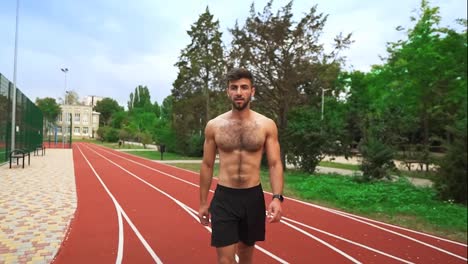 Portrait-of-a-tired,-shirtless-man-going-on-stadium-race-after-hard-training