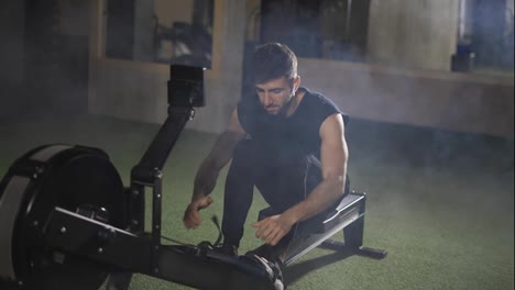 Handsome-athlete-works-out-in-gym-with-rowing-machine
