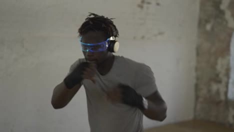 Boxer-practicing-shadowboxing-in-light-sport-studio-wearing-stylish-glasses