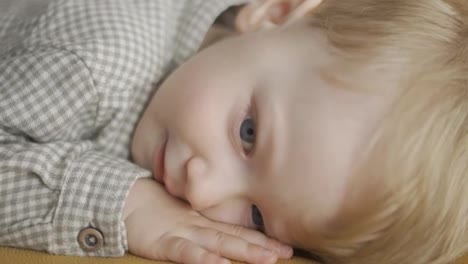 Close-up-face-of-cute-baby-toddler-with-blue-eyes-lying-smiling