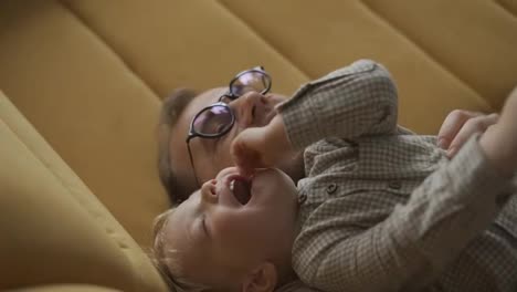 Daddy-plays-with-his-child-by-tickling-him