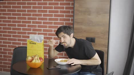 Guy-taking-corn-flakes,-funny-posing-for-camera