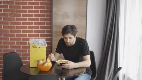 Man-has-breakfast-and-use-smartphone-at-home