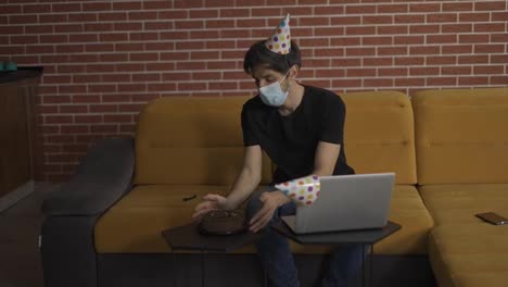 Man-in-mask,-lonely-guy-closing-laptop-after-distant-birthday-celebration