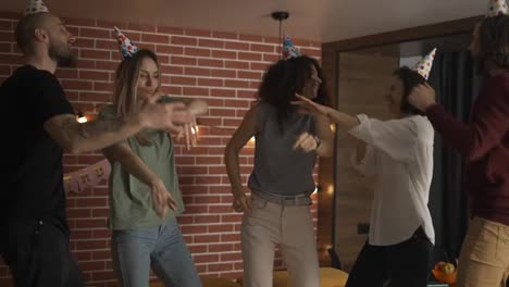 Joyful-friends-dancing-on-birthday-party-celebrating-exciting-holiday-at-home,-slowmo