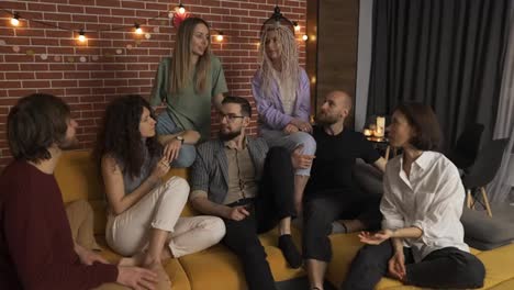 Group-of-happy-caucasian-men-and-women-in-conversation-on-sofa,-slow-motion