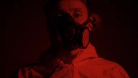 Red-smoke-shot-man-in-respirator-zipping-his-protection-suit