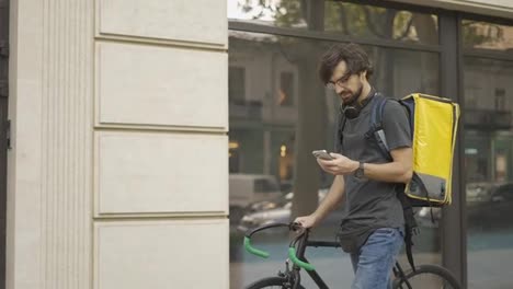 Delivery-man-who-is-going-and-texting-on-the-smartphone