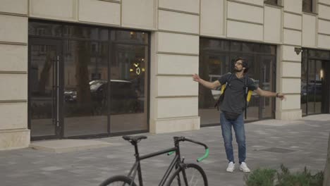 A-bearded-guy-with-a-backpack-is-fooling-around-and-dancing
