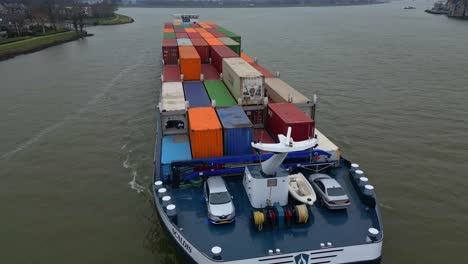 Fully-loaded-container-ship-Scaldis-travelling-along-Oude-Maas-in-Dordrecht-for-import,-export,-Aerial-shot
