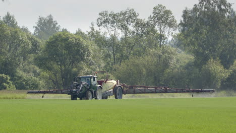 Sprayer-tractor-spraying-pesticides-on-farm-land-in-Hedemora,-Dalarna