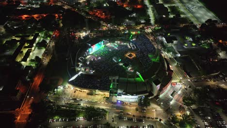 Aerial-view-around-the-illuminated-Estadio-Quisqueya-Juan-Maricha,-during-concert-night,-Santo-Domingo,-Dominican-Republic