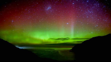Night-timelapse-shot-capturing-auroral-activity,-beautiful-Southern-light-Aurora-illuminate-the-dark-sky,-exhibiting-vibrant-dancing-waves-of-lights-at-Nugget-Point-New-Zealand-during-winter