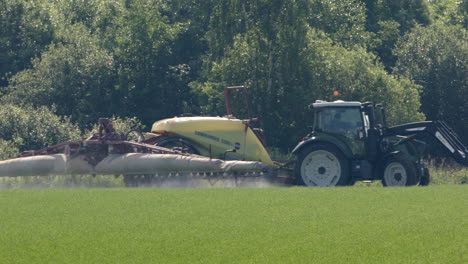 Agricultural-sprayer-tractor-spraying-pesticides-turns-around-in-farm-land