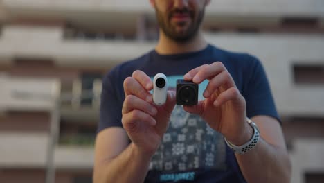 Male-Holding-DJI-Action-2-And-Insta360-Go-3-In-Hands-Showing-Size-Comparison