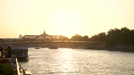 Grand-Palais-and-Passerelle-Léopold-Sédar-Senghor-bridge-on-the-river-Seine-at-sundown,-View-from-boat