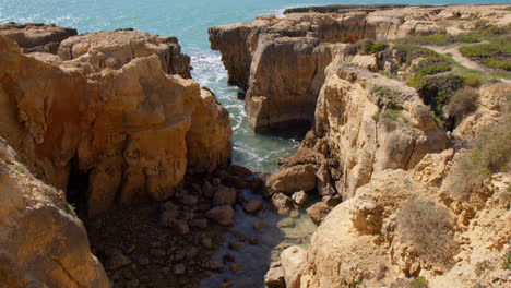 Scenery-Of-Clay-Orange-Cliffs-At-The-Rugged-Shore-Of-Praia-do-Evaristo-In-Albufeira,-Algarve,-Portugal