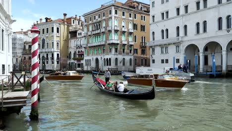 Gondel--Und-Wassertaxis-Fahren-Entlang-Des-Canal-Grande-In-Venedig-Am-Palazzo-Dei-Camerlenghi-Vorbei