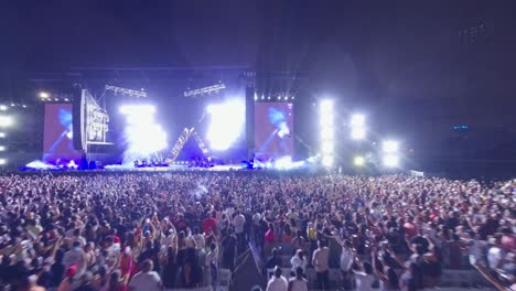 FPV-drone-shot-over-people-and-the-stage-at-Estadio-Quisqueya,-concert-night-in-Santo-Domingo