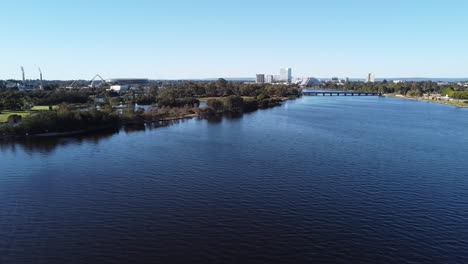 Drone-shot-sideways-across-Swan-River-view-of-Crown-Casino-Burswood,-Optus-Stadium-to-skyline-of-Perth,-Western-Australia