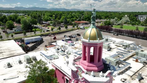 Aerial-pullback-past-gold-dome-and-pink-tower-of-iconic-Casa-Bonita,-Lakewood