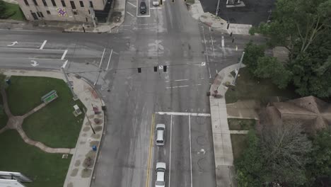 Intersection-in-downtown-Elkhart,-Indiana-with-truck-and-RV-turning-corner-with-stable-drone-video