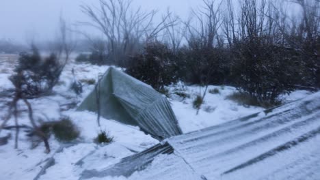 Two-survival-shelter-tarps-set-up-in-the-middle-of-a-snow-storm-in-the-remote-wilderness-of-Australias-snowy-mountains