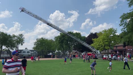 Fire-truck-with-ladder-extended-over-people-at-a-festival