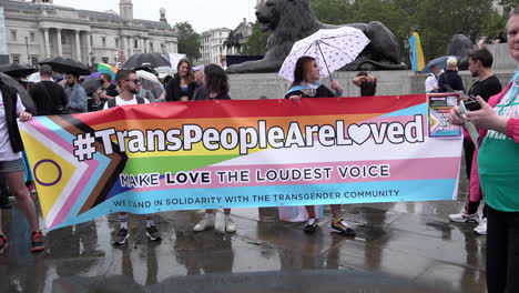 People-hold-a-banner-that-says,-“Trans-People-Are-Loved,-Make-Love-The-Loudest-Voice”-as-demonstrators-gather-at-Trafalgar-Square-to-prepare-to-march-at-London-Trans+-Pride-2023