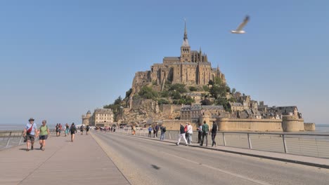 Tourists-going-to-visit-and-already-visited-the-medieval-abbey-of-Mont-Saint-Michel-in-France