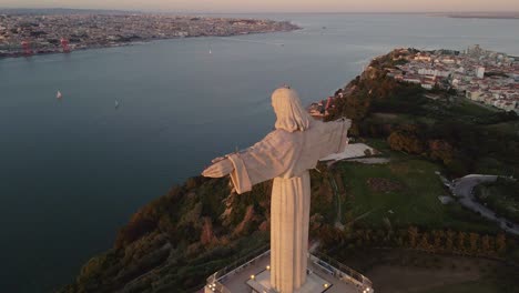The-christ-statue-monument-of-Lisbon-in-sunset-light,-taken-by-drone