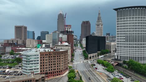 Downtown-Cleveland-OH-USA,-Drone-Shot-of-Traffic-on-Detroit-Avenue,-Federal-Courthouse-and-Central-Towers-on-Cloudy-Evening