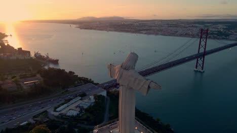The-christ-statue-monument-of-Lisbon-in-sunset-light,-taken-by-drone